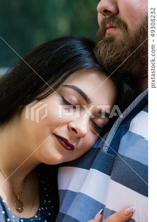 Two people in love stand hugging by large windows Two people in love stand hugging by large windows 49308232