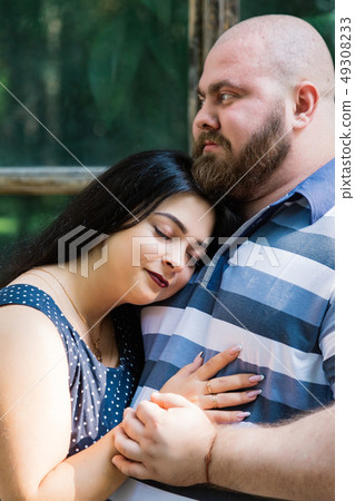 Two people in love stand hugging by large windows Two people in love stand hugging by large windows 49308233