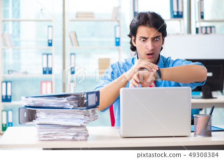 Handsome businessman unhappy with excessive work in the office  49308384