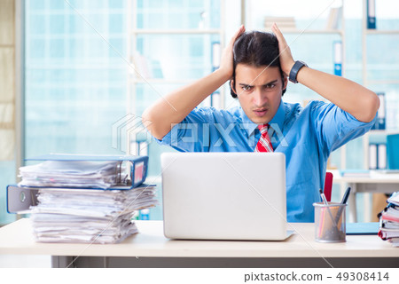Handsome businessman unhappy with excessive work in the office  49308414