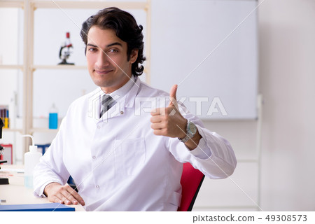 Young handsome chemist working in the lab Young handsome chemist working in the lab 49308573