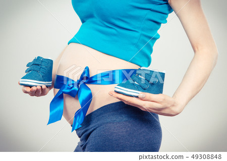 Pregnant woman with blue ribbon on belly Pregnant woman with blue ribbon on belly 49308848