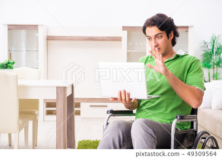 Young handsome man in wheelchair at home  49309564