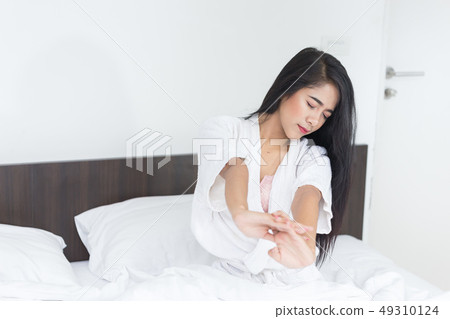 Asian Woman stretching in bed with her arms 49310124