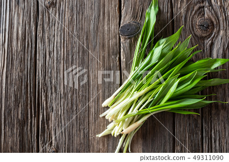 Fresh wild garlic leaves on a wooden background Fresh wild garlic leaves on a wooden background 49311090