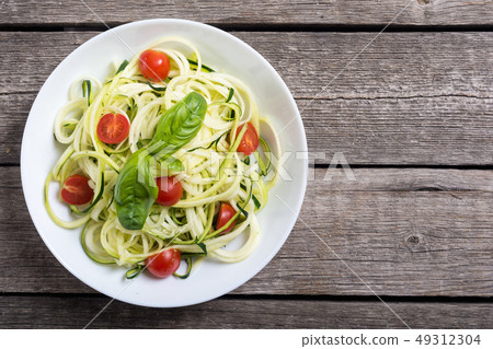 Zucchini pasta noodles with tomatoes . Healthy 49312304