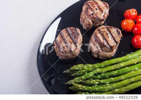Grilled filet mignon with asparagus and tomatoes 49312339