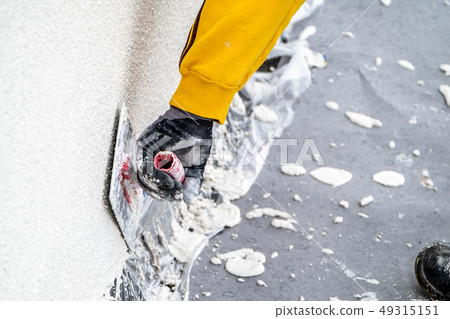 Construction worker plastering and smoothing concrete wall with cement Construction worker plastering and smoothing concrete wall with cement 49315151