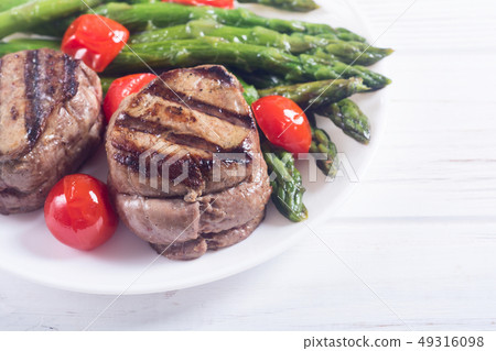 Grilled filet mignon with asparagus and tomatoes 49316098