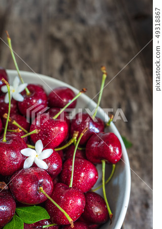 Bowl of fresh red cherries on wooden background 49318867