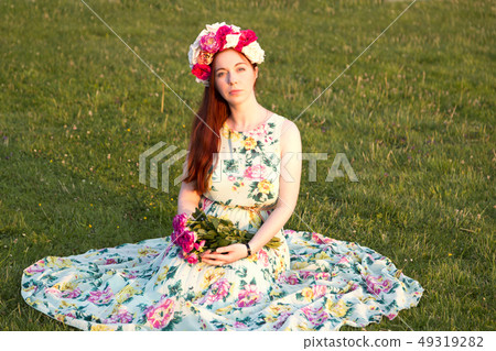 Beautiful woman in floral wreath holding flowers Beautiful woman in floral wreath holding flowers 49319282