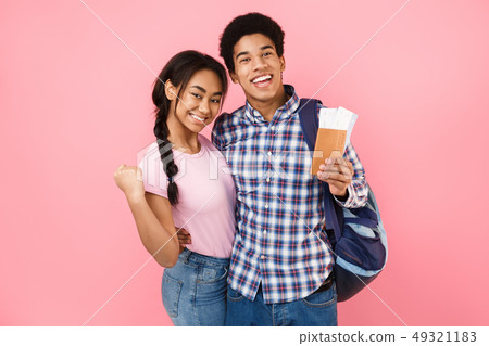 Happy teenage couple of tourists holding passport and tickets 49321183