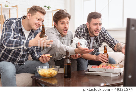 Disappointed friends watching football game, upset about loss Disappointed friends watching football game, upset about loss 49321574