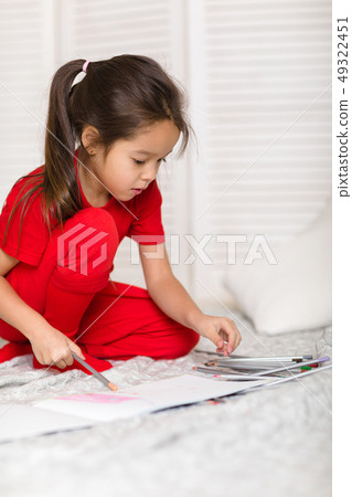 little child girl draws with pencils at home 49322451