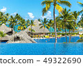 People and bungalows among palm trees in the resor 49322690