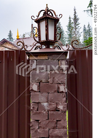 Wrought iron lamps brown with gold leaf on a fence with cobwebs Wrought iron lamps brown with gold leaf on a fence with cobwebs 49322764
