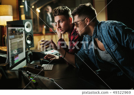 Sound engineer working in a music studio 49322969