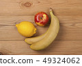 Lemon apple and bananas on a wooden background. 49324062