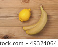 Lemon and bananas on a wooden background. 49324064