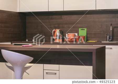 Modern kitchen with countertops, table and bar stool, dishes, kitchen loft style Modern kitchen with countertops, table and bar stool, dishes, kitchen loft style 49325123