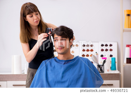 Young attracrive man visiting female barber Young attracrive man visiting female barber 49330721