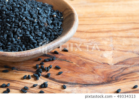 Black cumin seeds on a wooden spoon Black cumin seeds on a wooden spoon 49334313