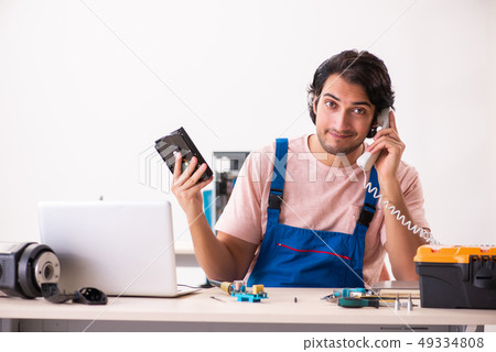 Young male contractor repairing computer Young male contractor repairing computer 49334808