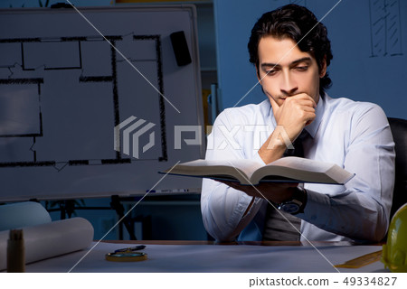 Young construction architect working on project at night  49334827