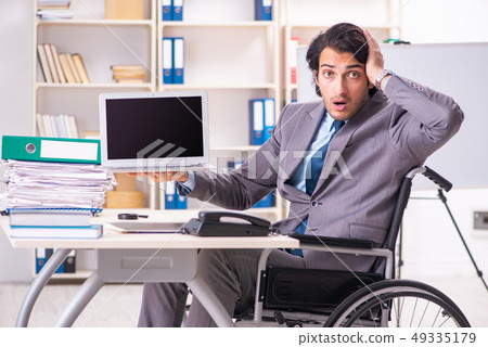 Young handsome employee in wheelchair at the office  49335179