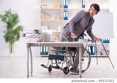 Young handsome employee in wheelchair at the office  49335201