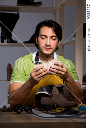 Young shoemaker in workshop at night  49335287