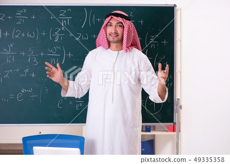 Arab teacher in front of chalkboard Arab teacher in front of chalkboard 49335358