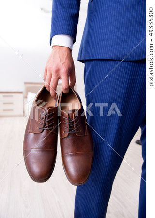 Young handsome businessman choosing shoes at home  49335800