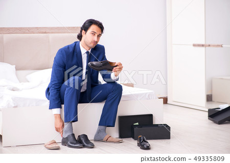 Young handsome businessman choosing shoes at home Young handsome businessman choosing shoes at home 49335809