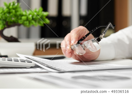 Businessman working in office and calculating Businessman working in office and calculating 49336516