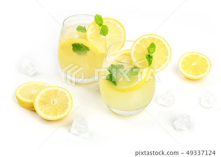 A photo of homemade lemonade in glasses, with fresh lemons, mint, and ice cubes, on a white A photo of homemade lemonade in glasses, with fresh lemons, mint, and ice cubes, on a white 49337124
