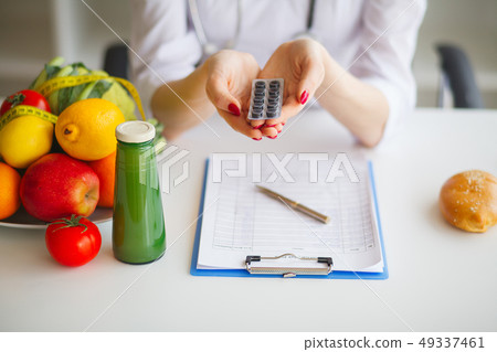 Diet. Female Nutritionist Holding Blisters of Pills 49337461
