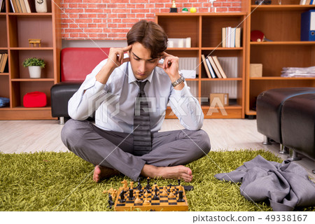 Young handsome boss playing chess during break Young handsome boss playing chess during break 49338167