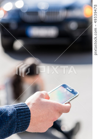 Hand of a man calling the emergency number for an injured woman 49339478