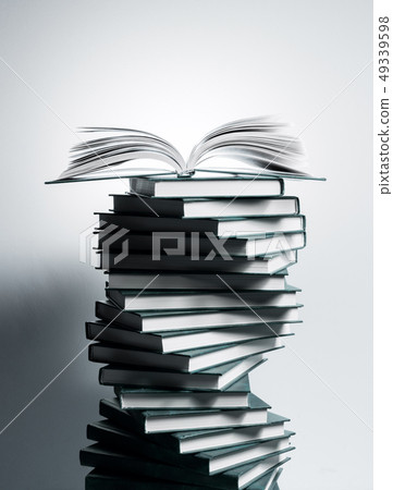 A spiral of stacks of books in the form of DNA and an open textbook at the top. 49339598