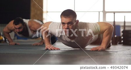 Close-up - Group of Male Muscular Friends Working Out in Gym. Close-up - Group of Male Muscular Friends Working Out in Gym. 49342074