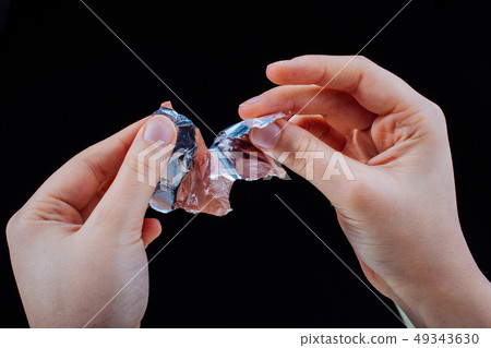 Hand tearing a heart shaped aluminium foil on Hand tearing a heart shaped aluminium foil on 49343630
