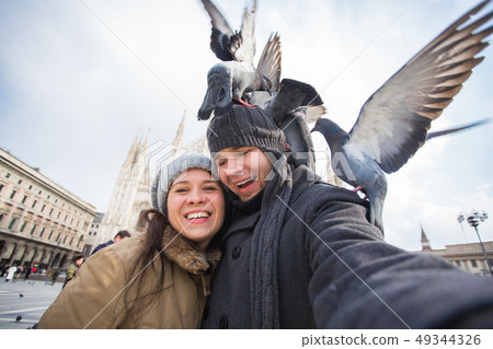Travel, Italy and funny couple concept - Happy tourists taking a self portrait with pigeons in front Travel, Italy and funny couple concept - Happy tourists taking a self portrait with pigeons in front 49344326