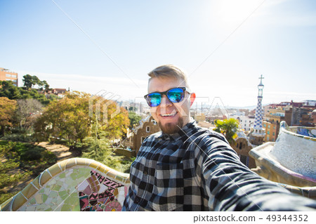 Travel and holidays concept - Happy guy making selfie portrait with smartphone in Park Guell 49344352