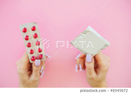 Pills or Condom. Antibiotics from venereal diseases. Concept of safe sex. Pills and condom lie on a 49345672