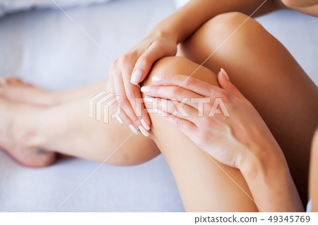 Knee Pain. Unhappy Woman Suffering From Pain in Leg at Home Knee Pain. Unhappy Woman Suffering From Pain in Leg at Home 49345769