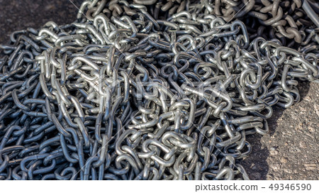 galvanized chain lies on the road under the rays of the Sun galvanized chain lies on the road under the rays of the Sun 49346590