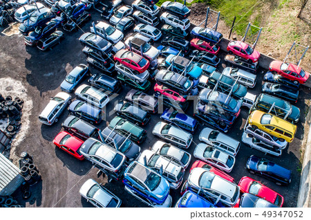 Lines of crushed cars wreck in scrapyard before being shredded recyling 49347052