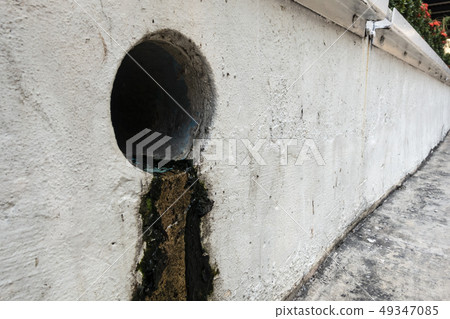 A sewer with moss on the wall shallow focus. A sewer with moss on the wall shallow focus. 49347085