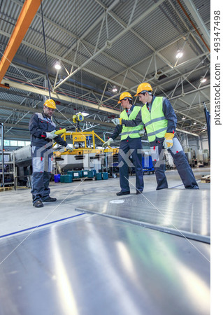 Workers with metal sheet lifting device Workers with metal sheet lifting device 49347498